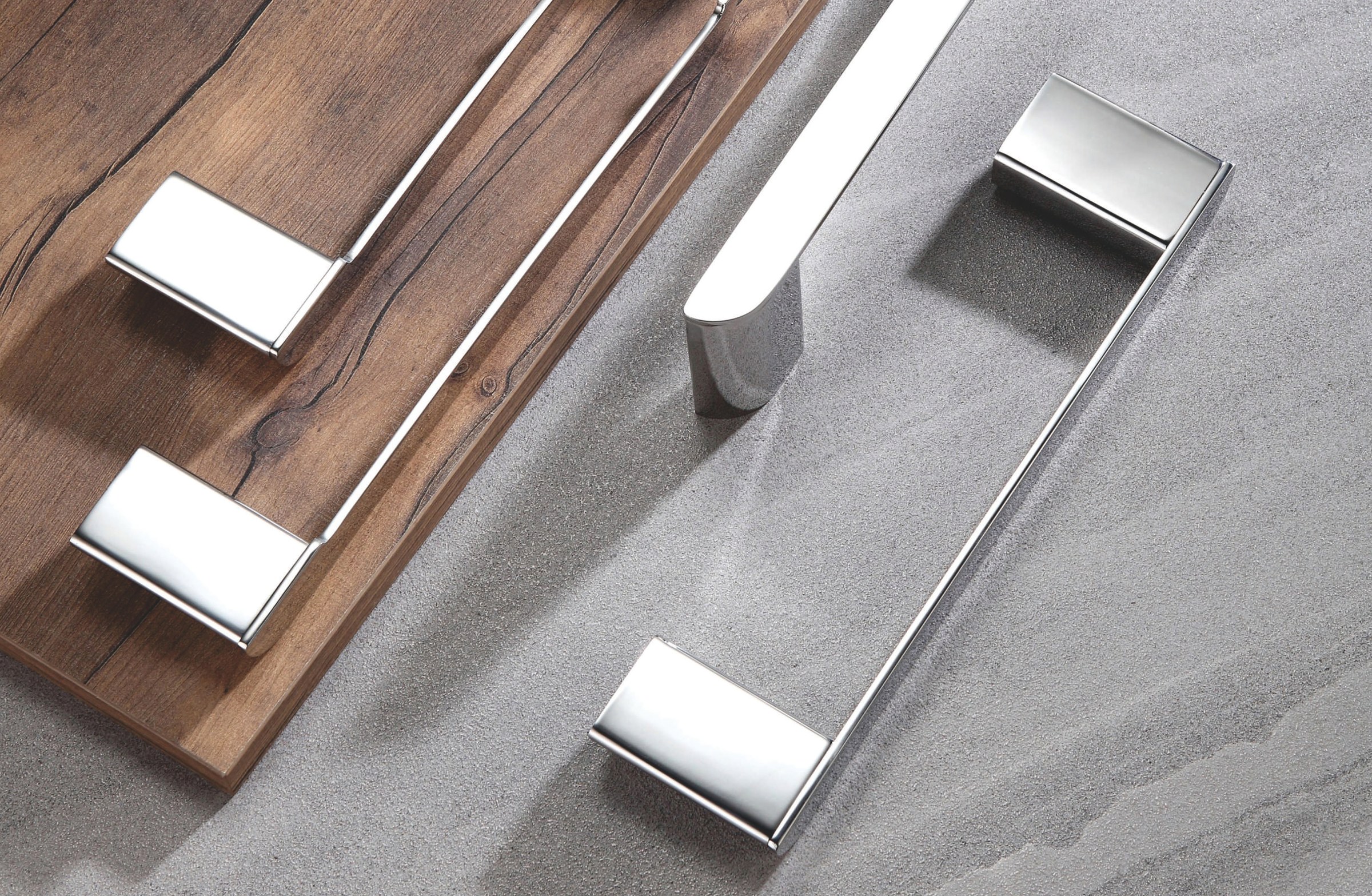 Stainless steel bathroom hardware displayed on wood and gray stone surfaces